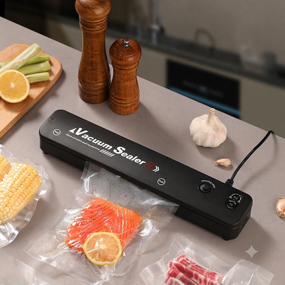 Scelleuse sous vide automatique noire sur un plan de travail avec saumon sous vide